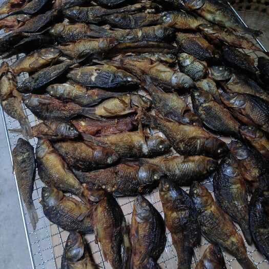 桂林采用鲜活禾花鱼刮净内脏，用香料腌进味后蒸熟再用谷壳烟薰烤制成